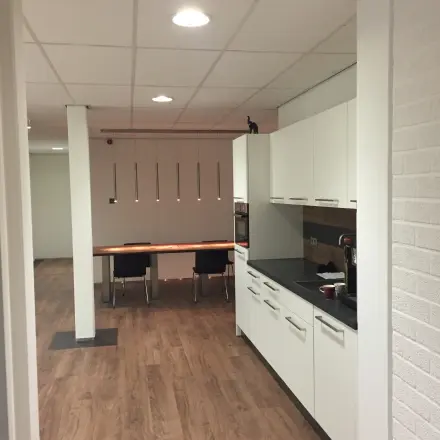Bright office space at Pompmolenlaan 9, Woerden, featuring a sleek kitchen nook and wooden flooring, perfect for office space rental.