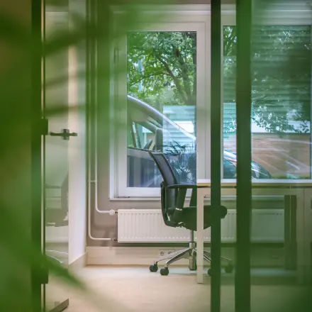 Bright office space for rent at Vijzelmolenlaan 9, Woerden, featuring a modern desk and chair facing a window with outdoor views.