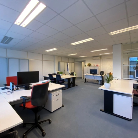 Interior view of a furnished office at Zaagmolenlaan 4, Woerden, showing multiple workstations available for office space rental. Bright and spacious with natural light.