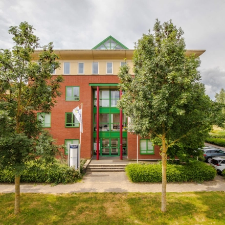 Exterior view of Mercurion 24 in Zevenaar, showcasing a red-brick office building with green accents, ideal for office space rental.