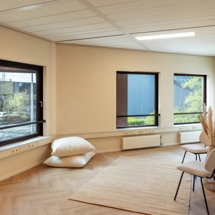 Inviting office space with natural light from large windows at Mercurion 24, Zevenaar. Ideal for rent office space, features minimalist seating and decor.
