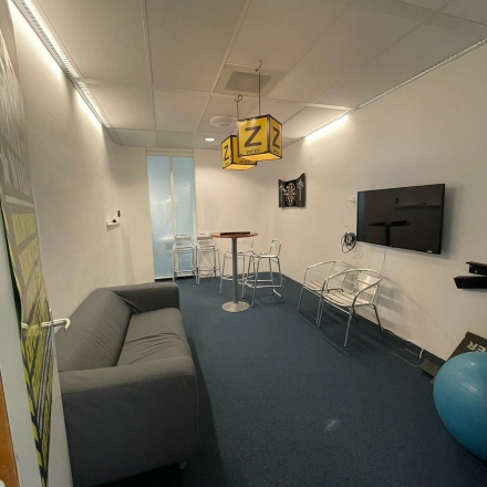 Cozy furnished office space at Baron de Coubertinlaan 35, Zoetermeer featuring seating, a television, and a unique decor, ideal for meetings or casual work sessions.