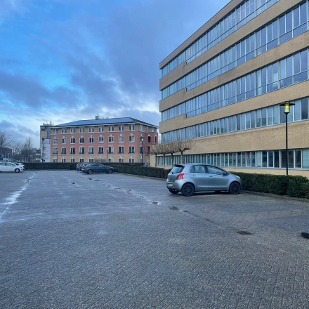 Exterior view of office building at Baron de Coubertinlaan 35 in Zoetermeer, featuring spacious parking area for office space rental.