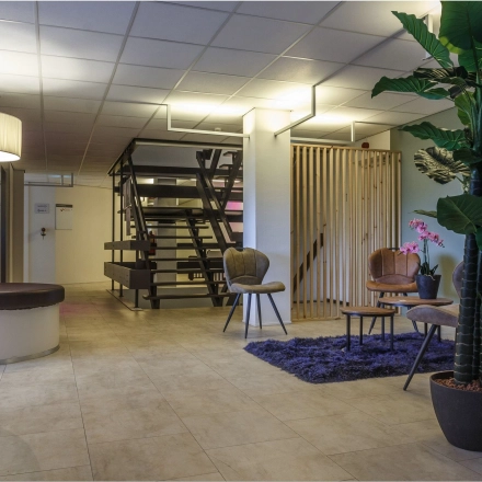 Modern office space lounge at Bredewater 26, Zoetermeer, featuring a chic waiting area with stylish furniture and plants, ideal for rent. Perfect for welcoming clients or informal meetings in a professional setting.