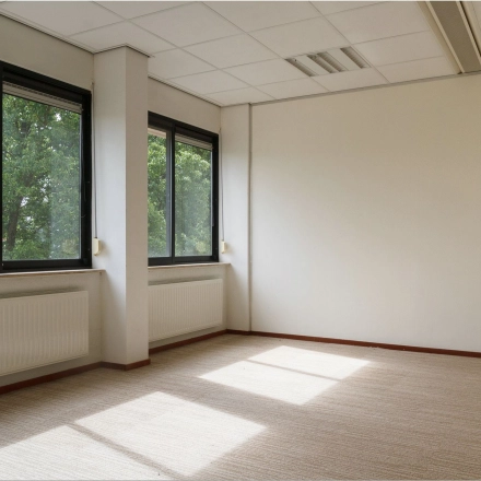 Spacious office with large windows at Bredewater 26, Zoetermeer, offering ample natural light, perfect for an office space rental. The room features a neutral carpet and heating units under the windows.