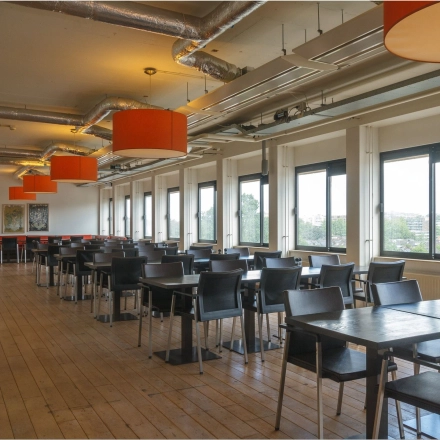 Spacious, well-lit workspace with natural light for office space rental at Bredewater 26, Zoetermeer. Features an open floorplan with ample seating and large windows offering scenic views.