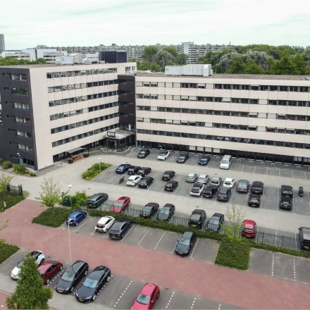 Exterior view of a modern office building at Bredewater 26, Zoetermeer, featuring ample parking. Ideal for office space rental, the building offers a professional setting with multiple levels.
