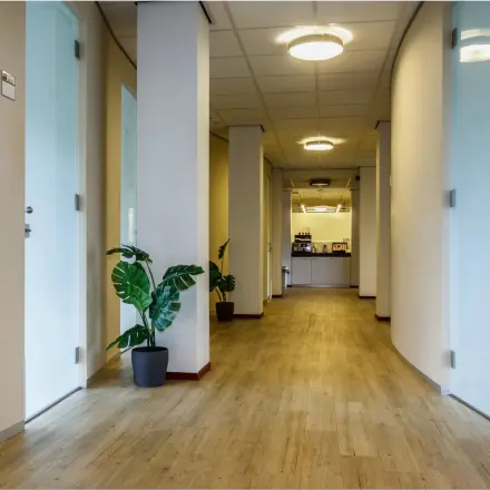 Bright hallway at Bredewater 26, Zoetermeer, leading to office space rental areas. Modern furnishings and decor.