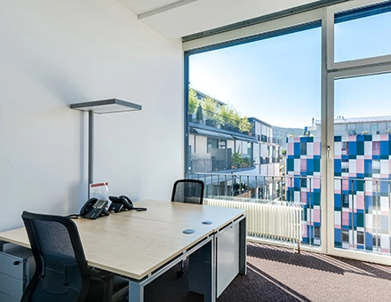 Bright office space at Badenerstrasse 47, Zürich Center with modern furnishings and large windows offering cityscape views, perfect for office space rental.