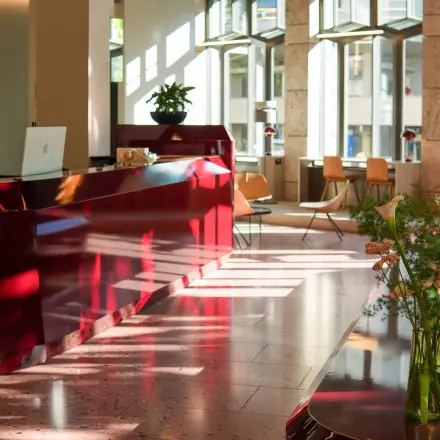Bright Zürich Center office featuring a glossy reception desk, modern furnishings, and natural light ideal for office space rental.