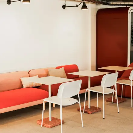At Ernst Nobs Platz 1 in Zürich Center, this office space rental features a vibrant seating area with red and white furniture, ideal for informal meetings or breaks.