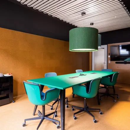 Stylish conference room at Uraniastrasse 31, Zürich Center, featuring vibrant green chairs and a large table, ideal for office space rental.