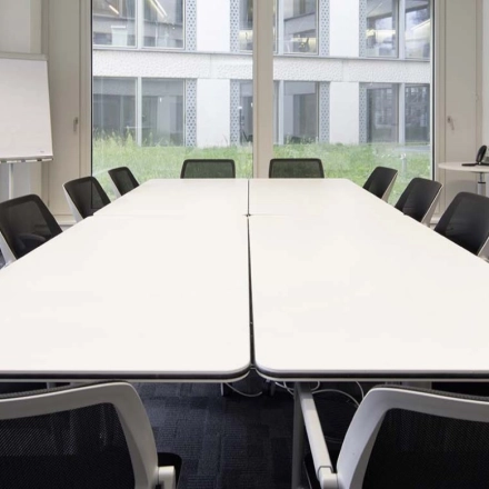 Office conference room at Europaallee 41, Zürich Mitte, featuring a central table, modern chairs, and large windows. Ideal for office space rental.