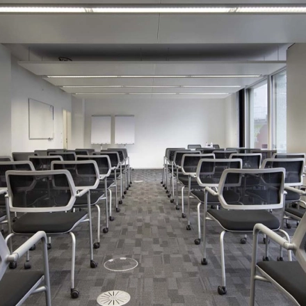 Modern office space with rows of chairs facing whiteboards and large windows, ideal for training sessions or presentations at Europaallee 41.