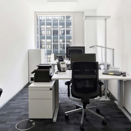 Bright and functional workspace available to rent at Europaallee 41, Zürich Mitte, featuring modern furnishings and ample natural light from large windows.