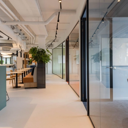 Modern office space at Hanzelaan 351-361, Zwolle with sleek furniture and glass partitions, available for rent. Includes a conference room and adjacent workspaces.