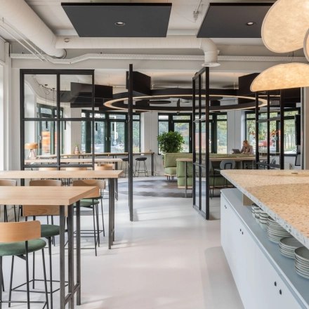 Modern office space with sleek tables and chairs, large windows, and stylish lighting at Hanzelaan 351-361. Ideal for those looking to rent office space in Zwolle.