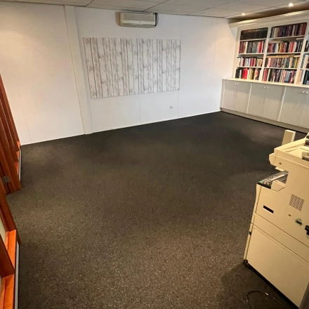 Spacious office at Pascalweg 6, Zwolle, featuring a carpeted floor, bookshelves, and light décor. Ideal for office space rental and flexible workspace needs.
