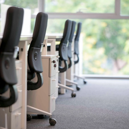 Espacio de trabajo amueblado con sillas ergonómicas y escritorios en un entorno moderno en Barcelona. Ideal para alquilar una oficina que ofrece comodidad y funcionalidad.