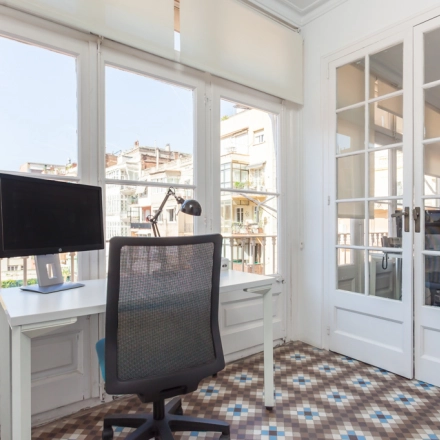 Espacio luminoso y fresco para alquilar una oficina en Rambla de Catalunya, Barcelona Eixample, con grandes ventanas y suelo de baldosa.