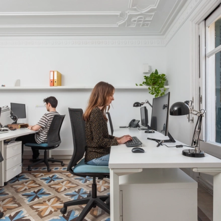 Espacio de trabajo iluminado en alquiler de oficinas en Rambla de Catalunya 125, Barcelona Eixample, con personal trabajando tranquilamente.