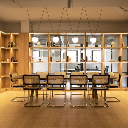 Espacio luminoso para alquilar una oficina en Paseo Imperial 14, Madrid Centro, con estanterías llenas y mobiliario moderno.