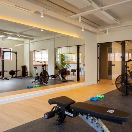Moderno espacio de alquiler de oficinas en Paseo Imperial 14, Madrid Centro, con área de gimnasio y equipo de fitness.