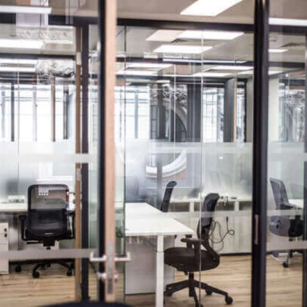 Espacio moderno y transparente ideal para alquilar una oficina en Calle de Alfonso XII 62, Madrid Retiro, con mesas y sillas ergonómicas.