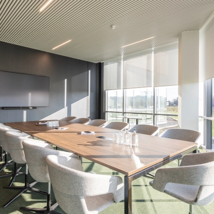 Moderne vergaderruimte in een kantoorpand op Korte Keppestraat 19, Aalst, met een grote vergadertafel, comfortabele stoelen en veel natuurlijk licht. Ideaal voor kantoorruimte huur.