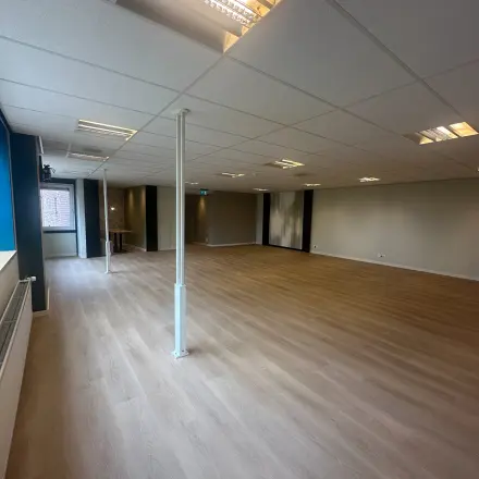 Ruime kantoorruimte te huur op Hollandse Kade 38, Abcoude. Het interieur is ongemeubileerd met een houten vloer en helder verlichte plafonds, ideaal voor kantoorpand aanpassingen en personalisatie.