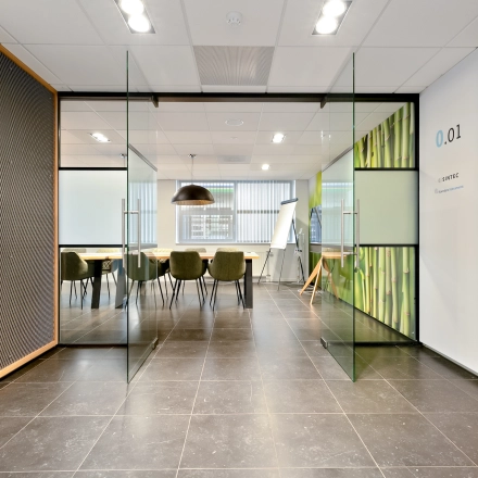 Moderne kantoorruimte te huur aan Jool Hulstraat 2-14 in Almere Stad met glazen deuren en vergadertafel met stoelen.