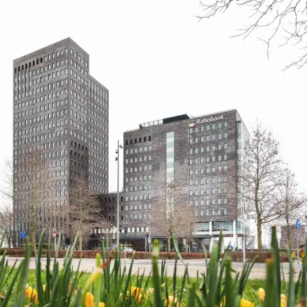 Kantoorpand aan de Landdrostdreef 124 in Almere Stad met moderne architectuur, omringd door groen en een open straat. Ideaal voor bedrijven die kantoorruimte willen huren in een levendige zakelijke omgeving.