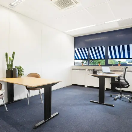 Lichte kantoorruimte op Markerkant 1310, Almere Stad met twee bureaus, stoelen en planten. Grote ramen zorgen voor veel natuurlijk licht in het kantoorpand.