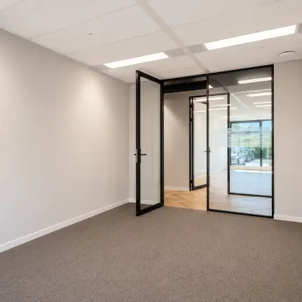 Kantoorruimte op Veluwezoom 15 in Almere Stad met strakke muren en glazen deuren. Ideaal voor wie een kantoor wil huren en een startklare werkplek zoekt.