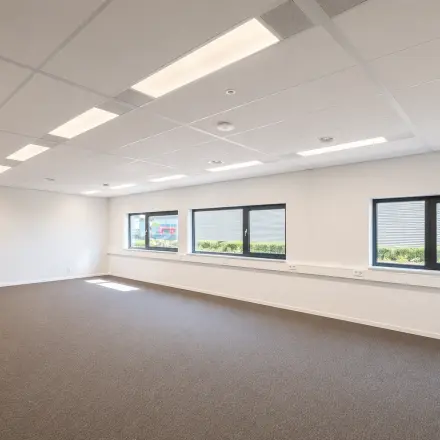 Lichte, open kantoorruimte met grote ramen aan de Veluwezoom 15 in Almere Stad, geschikt voor wie een functionele kantoorruimte wil huren. Neutraal interieur biedt potentieel voor een persoonlijke touch.