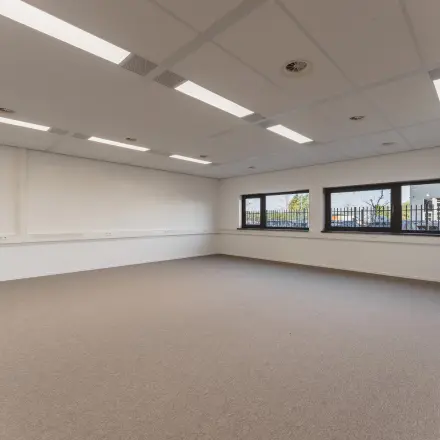 Lichte kantoorruimte te huur in Almere Stad, gelegen in een modern kantoorpand aan de Veluwezoom 15. De ruimte biedt grote ramen met uitzicht en een neutraal interieur.
