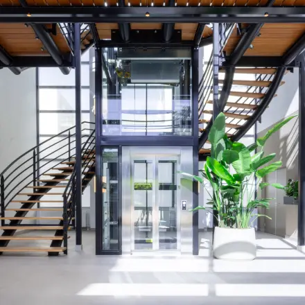 Ruime en lichte entree met moderne trap en glazen lift in een kantoorpand, ideaal voor kantoorruimte huren aan de Maanlander 43 in Amersfoort Calveen.