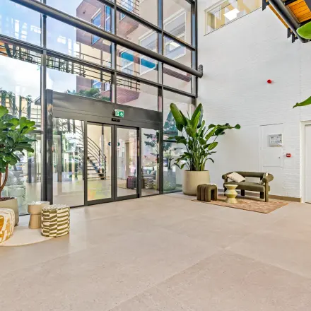 Ruime ingang met moderne zitruimte en veel natuurlijk licht in het kantoorpand op Maanlander 43, Amersfoort Calveen. Ideaal voor kantoorruimte huren.