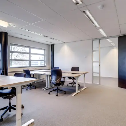 Lichte kantoorruimte te huur op Maanlander 47, Amersfoort Calveen, met moderne bureaus en stoelen, ideaal voor professionele werkomgeving.