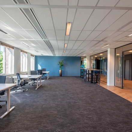 Moderne kantoorruimte met ruime werkplekken en veel natuurlijk licht aan Stadsring 115, Amersfoort Centrum. Grote ramen en een strakke inrichting bieden een inspirerende omgeving voor een productieve werkdag.
