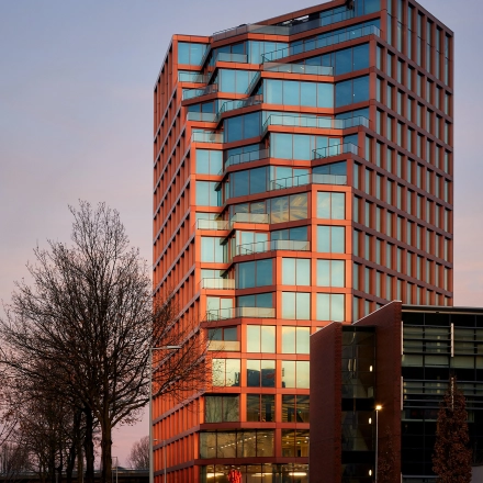 Exterieur van een modern kantoorpand aan de H.J.E. Wenckebachweg 230-258 in Amsterdam Amstel Business Park. Strakke gevel met glas en reflecterende elementen, ideaal voor bedrijven die kantoorruimte willen huren.
