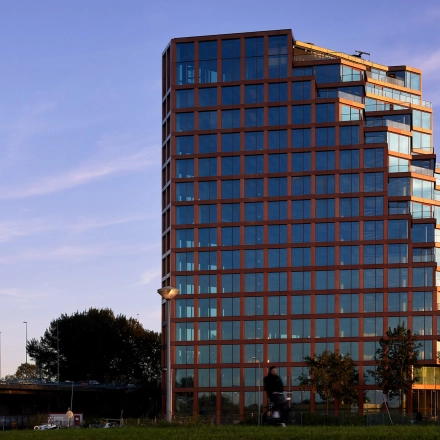Modern kantoorpand gelegen aan de H.J.E. Wenckebachweg 230-258 in Amsterdam Amstel Business Park, omringd door groen en bereikbaar via nabijgelegen wegen. Ideaal voor bedrijven die kantoorruimte willen huren.