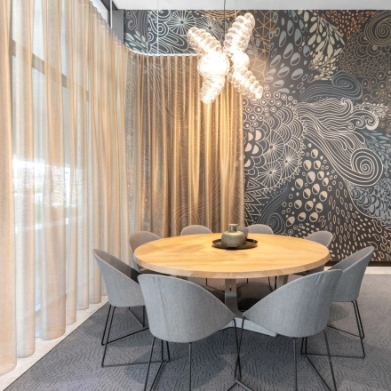 Moderne vergaderruimte in het kantoorpand op Trompenburgstraat 2c, Amsterdam Amstel Business Park, met een stijlvol ingerichte tafel en stoelen, omringd door artistieke muren en veel natuurlijk licht, ideaal om kantoorruimte te huren.