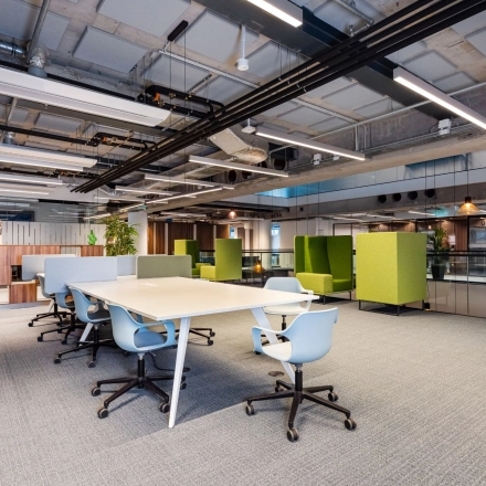 Moderne kantoorruimte huren in Amsterdam Amstel Business Park, Trompenburgstraat 2c. Licht interieur met open werkplekken, groene accenten en uitnodigende zitgelegenheid.