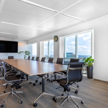 Moderne vergaderruimte in kantoorpand op Amstelplein 8, Amsterdam Amstel, met grote tafel en verstelbare stoelen bij ruime ramen. Ideaal voor kantoorruimte huren.