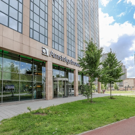 Kantoorpand aan Prins Bernhardplein 200 in Amsterdam Amstel, met moderne gevel en grootse ramen. Ideale locatie voor kantoorruimte huren in het Amstelgebouw. Gelegen in een groene omgeving.