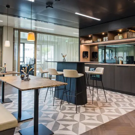 Moderne en stijlvolle kantoorruimte te huur in Amsterdam Buitenveldert op Walborg 2A, voorzien van een elegante bar met comfortabele zitmogelijkheden, ideaal voor informeel overleg.