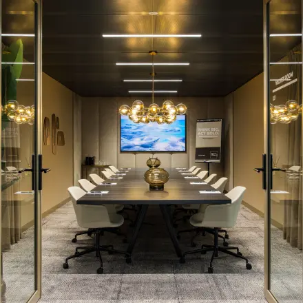 Moderne en stijlvolle vergaderruimte in kantoorpand Walborg 2A, Amsterdam Buitenveldert, met een lange tafel, verlichting en stoelen. Perfect voor wie kantoorruimte wil huren voor zakelijke bijeenkomsten.