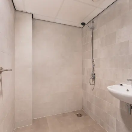 Een moderne badkamer in het kantoorpand op Walborg 2A, Amsterdam Buitenveldert. De ruimte heeft een douche en een wastafel en kan nuttig zijn voor medewerkers tijdens werkuren. Een ideale toevoeging bij het huren van kantoorruimte.