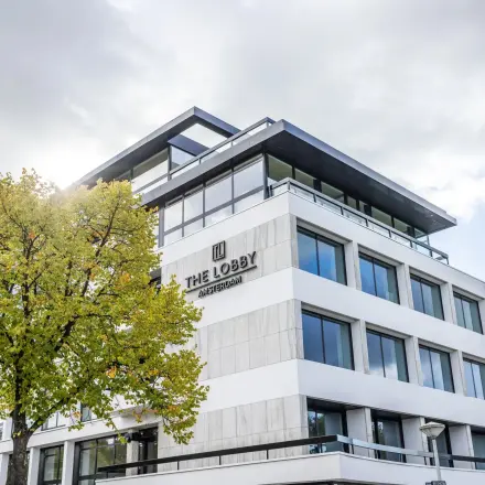 Kantoorpand aan Zwaansvliet 1 in Amsterdam Buitenveldert, modern gebouw met grote ramen en een boom aan de voorzijde. Geschikt voor kantoorruimte huren.